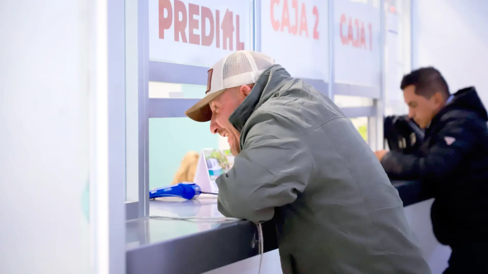 Hombre frente a caja de cobro de impuesto predial